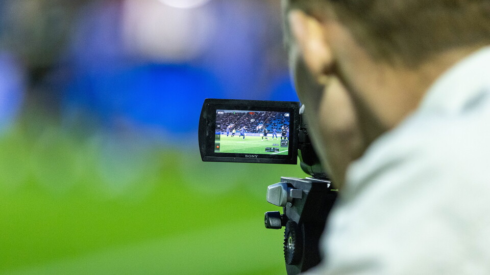 Man filming the football with video recorder